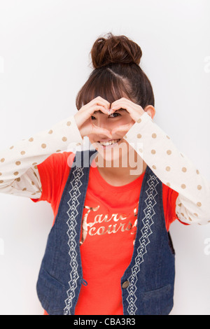 Young woman making a heart shape with hands Stock Photo