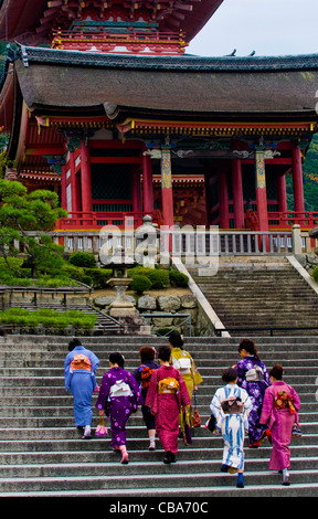 A group of Japanese women with traditional clothing walk up to a temple in Kyoto Stock Photo