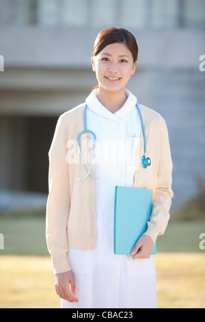smiling-young-japanese-female-nurse-walking-in-the-corridor-stock-photo
