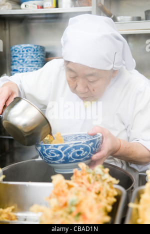 An old Japanese lady preparing home made tempura soba at a soba stall in Tokyo Japan Stock Photo