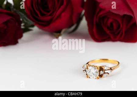 Golden diamond ring and rose on white background Stock Photo