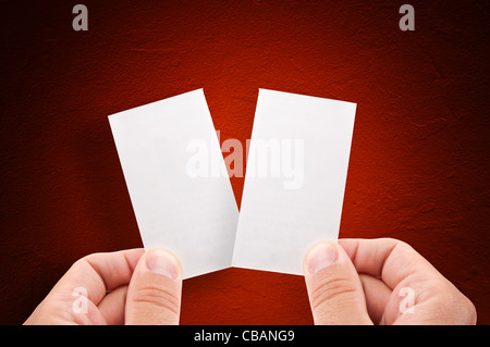 Hands holding empty business cards over grungy red background Stock Photo
