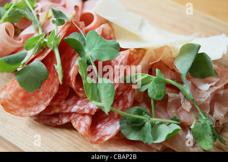 salami parma ham platter with pea shoots served on a wooden platter Stock Photo