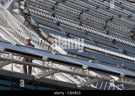 A worker on the roof of the Micro-E Hotel, world's largest solar powered hotel. China Solar Valley, Dezhou, Shandong, China Stock Photo