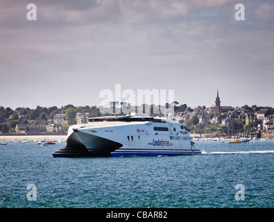 Condor Ferries catamaran coming into harbour at St Malo with town of Dinard in the background, Brittany, France Stock Photo