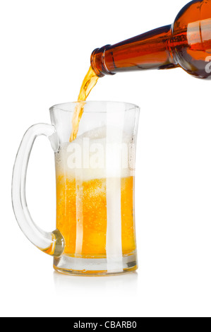 Beer pouring from glass bottle into a mug over white background Stock Photo