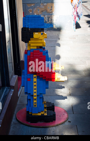 Large Lego figure stands in front of the toy shop. Stock Photo