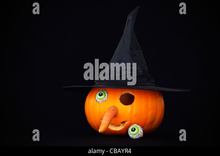 Halloween lantern in the shape of a witches face with one eye missing against a black background Stock Photo