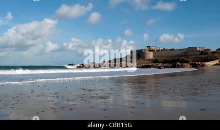 Surf in Corblets bay, Alderney, Channel Islands, with Fort Corblets on right Stock Photo