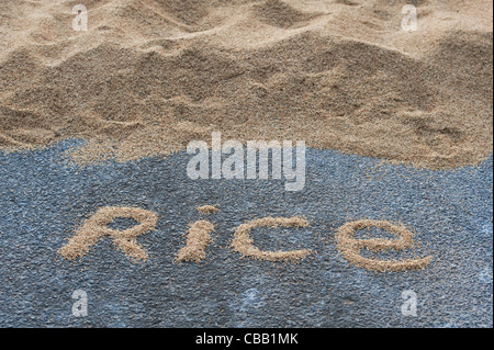 RICE word in front of Drying rice grain on an Indian road. Andhra Pradesh, India Stock Photo