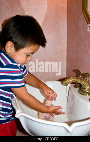 Hispanic toddler boy washing his hands in sink with liquid soap and running water. MR © Myrleen Pearson Stock Photo