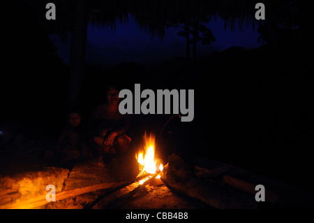 Embera Indian mother and son behind a bonfire in the jungle during the nightfall at the Embera Puru community in Panama Stock Photo