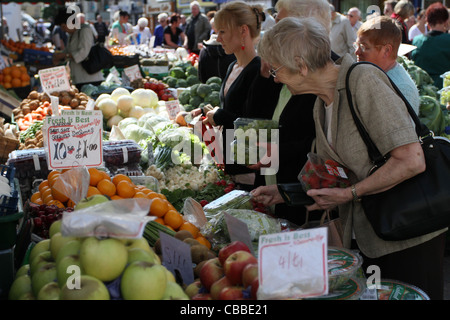 shoppers selecting fresh fruit and vegetables from a busy market stall on Doncaster Market Stock Photo