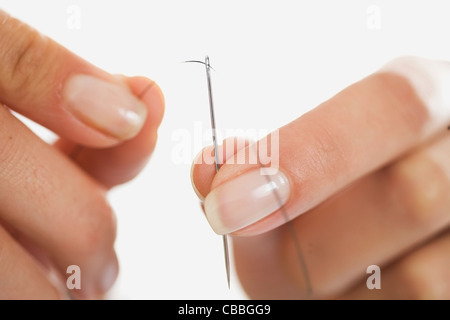 Close up of woman threading needle Stock Photo