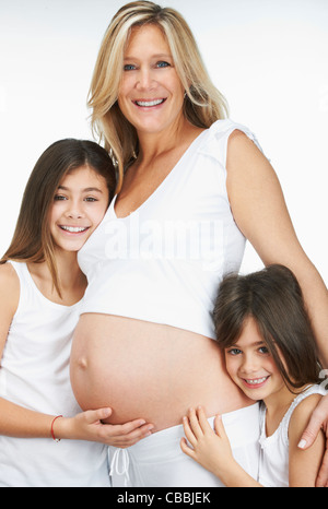 Pregnant mother hugging daughters Stock Photo