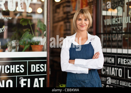 Smiling waitress standing in cafe Stock Photo