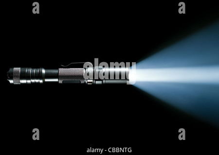 tactical police and military flashlight on black background with visible beam of light Stock Photo