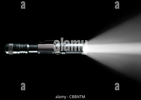 tactical police and military flashlight on black background with visible beam of light Stock Photo