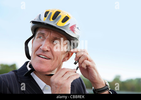 Businessman putting on bicycle helmet Stock Photo