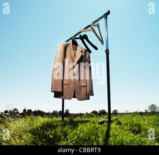 Suit jacket hanging in field Stock Photo
