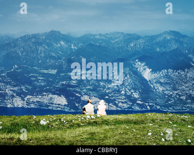 Couple sitting on rural hillside Stock Photo