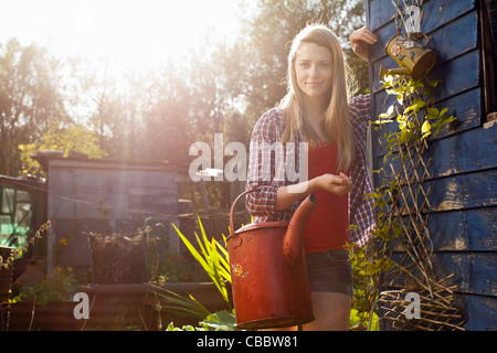 Woman holding watering can in garden Stock Photo