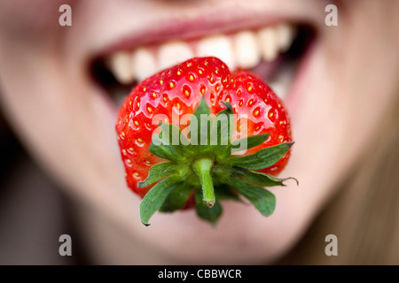 Close up of strawberry in woman’s mouth