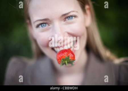 Close up of strawberry in woman’s mouth