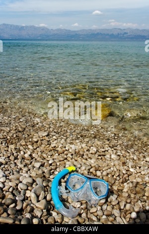 Diving mask lying on pebble beach, Croatia Stock Photo