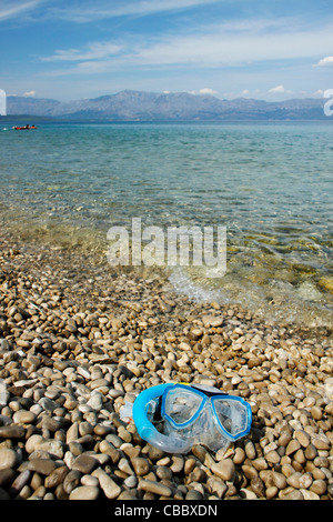 Diving mask lying on pebble beach, Croatia Stock Photo