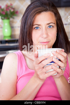 Attractive woman wearing pajamas drinking coffee Stock Photo