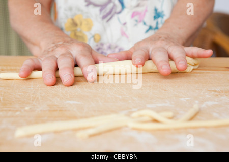 Close up of older woman rolling dough Stock Photo