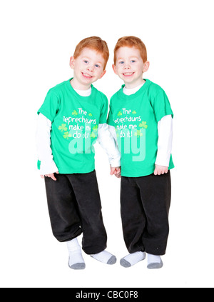 Smiling redheaded twins holding hands isolated on white Stock Photo