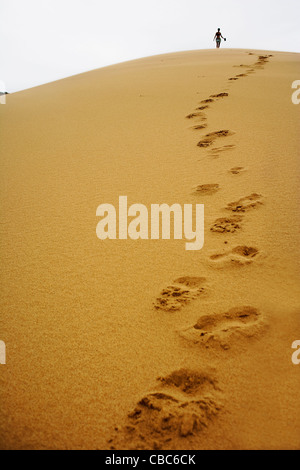 Footsteps in sand dune Stock Photo