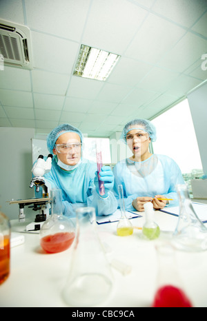 Surprised chemists making experiment with new substance in laboratory Stock Photo