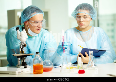 Serious chemists making experiment with new substance in laboratory Stock Photo