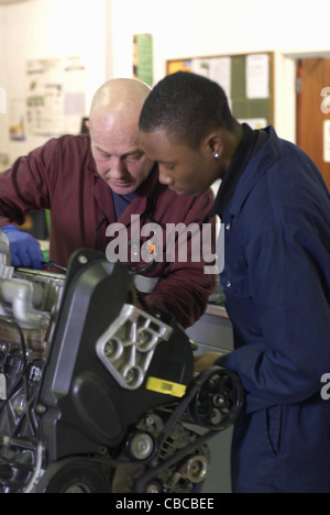 Teacher helping student with car engine Stock Photo