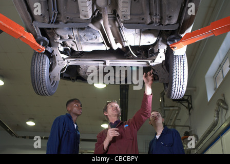 Teacher helping students with car engine Stock Photo