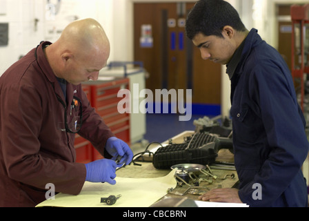 Teacher helping student with car parts Stock Photo