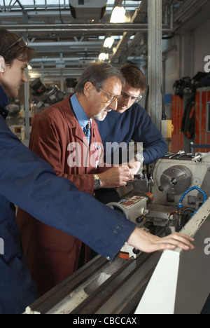 Teacher helping students in shop class Stock Photo