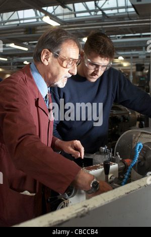Teacher helping students in shop class Stock Photo