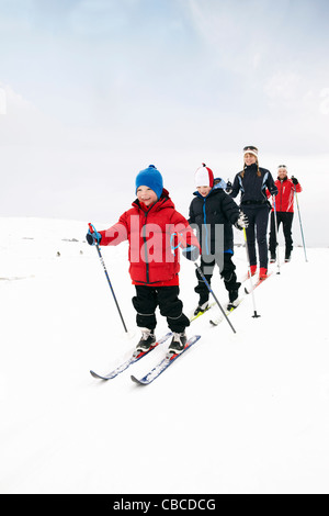 Family cross country skiing in snow Stock Photo