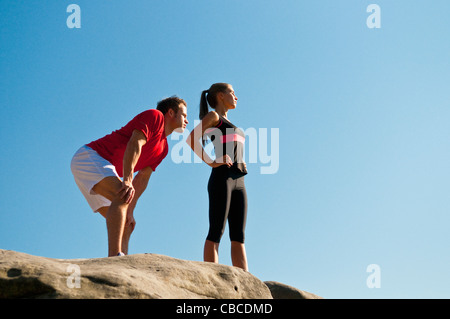 Rock climbers standing on boulder Stock Photo
