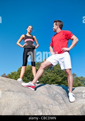 Rock climbers standing on boulder Stock Photo