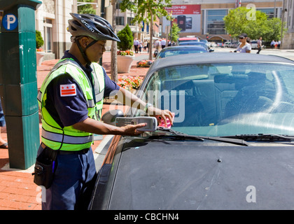 A parking enforcement places a ticket on car - Washington, DC USA Stock Photo