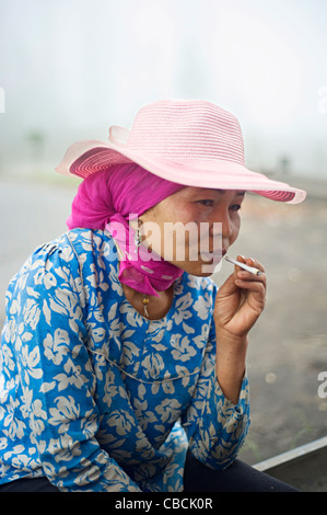 Unidentified indonesian woman smoking cigarette. Smoking in Indonesia is a common practice Stock Photo