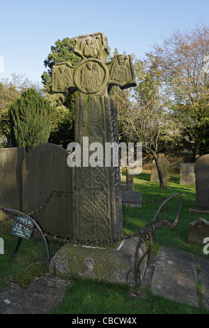 8th Century Saxon Cross in the graveyard of St Lawrence church, Eyam, Derbyshire, England grade I listed Stock Photo