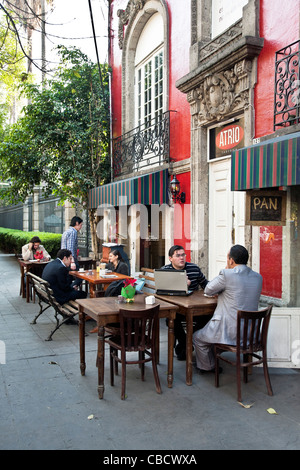 charming sidewalk cafe in a beautiful old building with people seated outdoors on a quiet street in Roma District of Mexico City Stock Photo