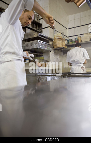 Chefs working in commercial kitchen Stock Photo