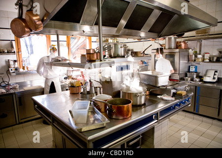 Chefs working in commercial kitchen, pot cooking on stove Stock Photo